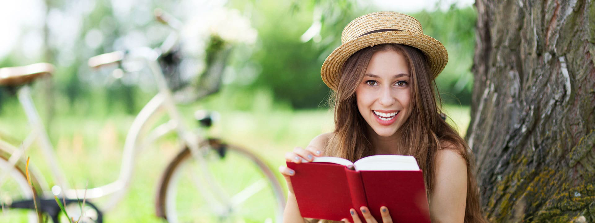 Young woman smiling reading a book